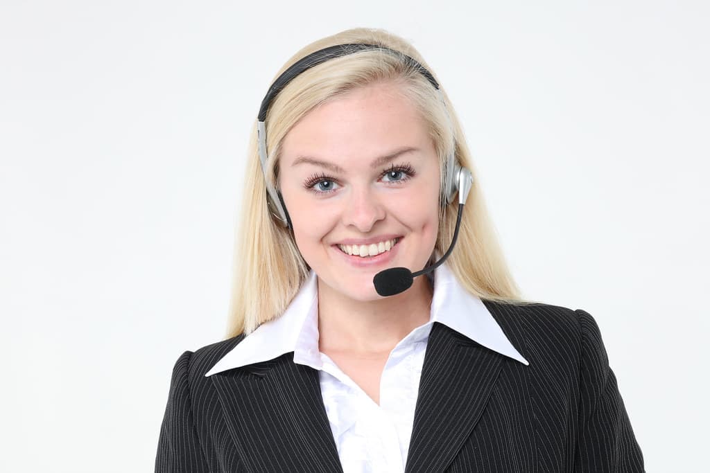 Customer service representative wearing a headset working at a computer in an office