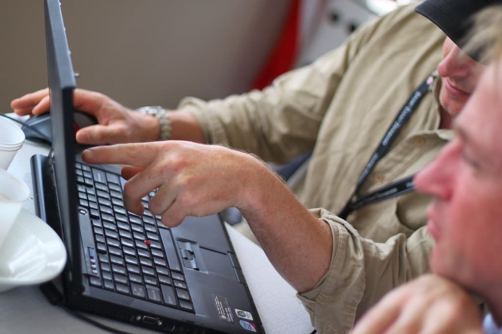 Sales professional reviewing an AI-powered CRM dashboard on a laptop in an office