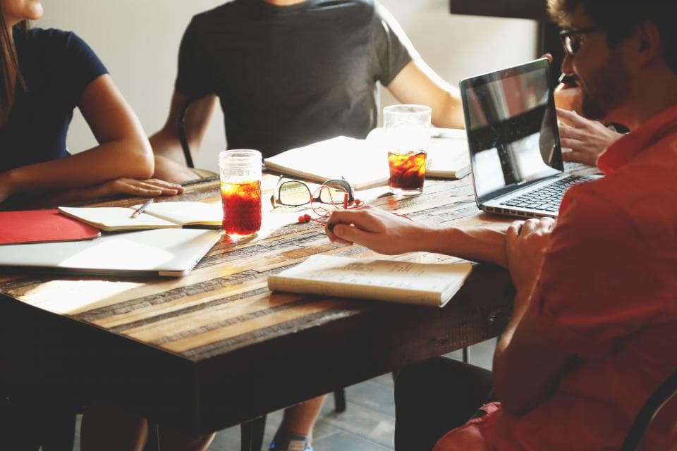 A small business team comparing CRM software options on a laptop in a bright office
